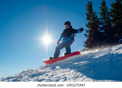 Snowboarder Riding Snowboard in the Mountains at Sunny Day. Snowboarding and Winter Sports - Shutterstock ID 1591271947