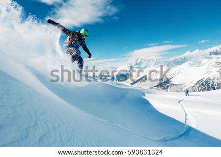 snowboarder is riding with snowboard from powder snow hill or mountain very fast