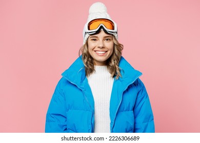 Snowboarder smiling happy woman 20s wear blue suit goggles mask hat ski padded jacket spend extreme weekend look camera isolated on plain pastel pink background. Winter sport hobby trip relax concept