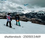 Snowboarders overlook views in Telluride, Colorado