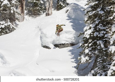 Snowboarding Man Jump Off Cliff In Sunny Powder Snow