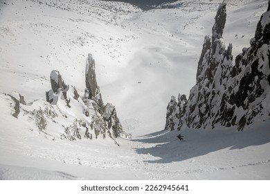 Snowboarding in the snowy mountains among rocks, winter freeride extreme sport. Skiing, Skier, Freeski - freeride, man snowboarding downhill