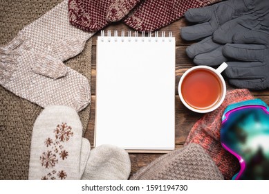 Snowboarding Tips Mock Up. Snowboard Gear List Template. Blank Page Notepad With Copy Space And Snowboard Googles, Cuf Of Black Tea On Brown Wooden Table Flat Lay Background.