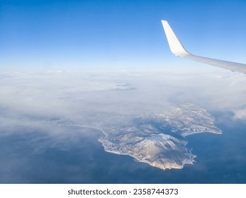 Snow-capped low volcano seen under clouds from the sky (Hakodate, Hokkaido, Japan) - Powered by Shutterstock