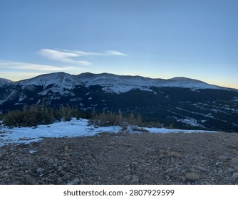 Snow-capped mountain range glowing at winter dusk