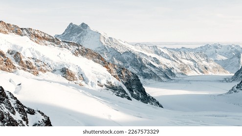 The snow-capped mountain stands tall against a clear blue sky, its jagged peaks and pristine snow reflecting the beauty and power of nature - Powered by Shutterstock