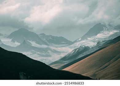 Snow-Capped Mountains with Dramatic Clouds
A rugged mountain landscape with snow-covered peaks and dramatic clouds overhead, creating a striking natural scene.
