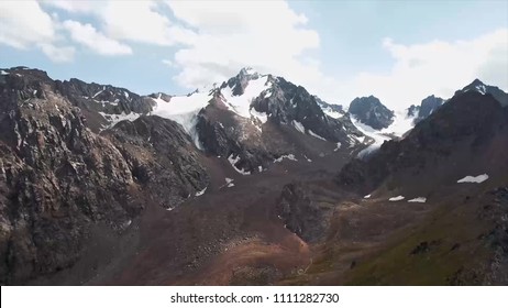 Snow-capped mountains. Stock. Aerial view on Mountains with snow cap, beautiful nature landscape with blue sky background