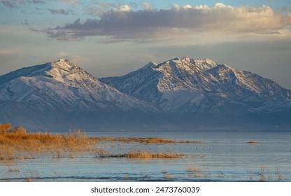 Snow-Capped Mountains at Sunset Over a Calm Lake - Powered by Shutterstock