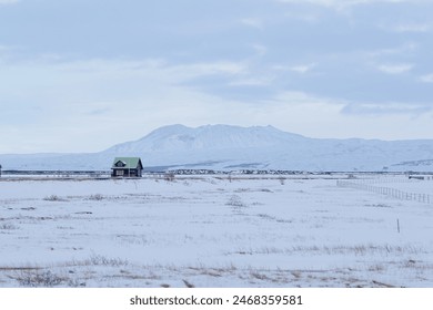 Snow-covered cabin with mountain backdrop - Powered by Shutterstock