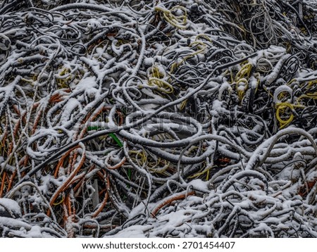 Snow-covered cables forming an abstract pattern, close-up industrial texture in winter.