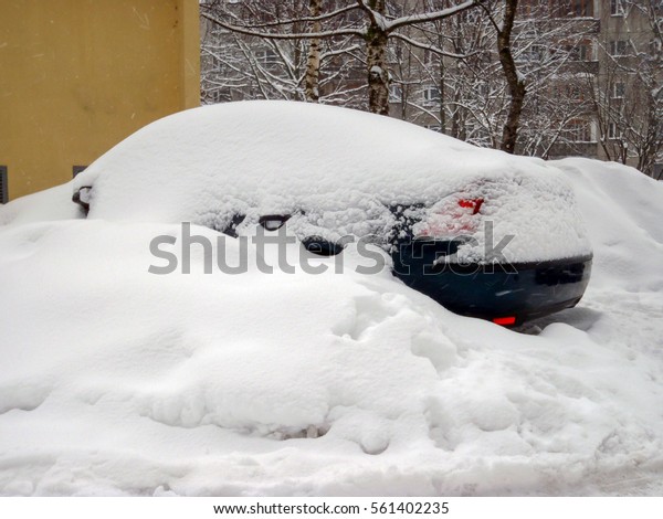 Snow-covered cars in the\
yard.