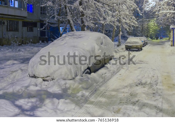 Snow-covered cars in the\
yard