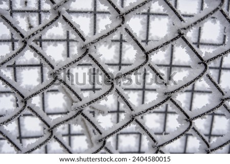 snow-covered fence in winter, fallen snow, frost and precipitation, freezing rain, close-up