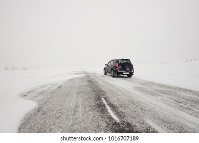 Snow-covered Fields And A Road In Winter During A Blizzard And A Car