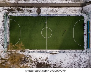 Snow-covered football field. Aerial drone top view. Cloudy winter day.