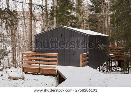 Snowcovered forest setting showcasing charming wooden cabin exterior