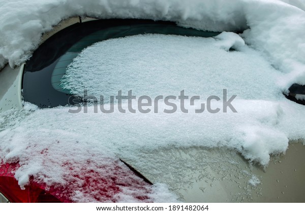 Snow-covered frozen car covered with snow.\
Winter road. Danger of winter driving. Car snow removal. Dangerous\
traffic situation.