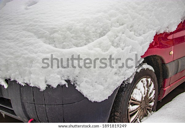 Snow-covered frozen car covered with snow.\
Winter road. Danger of winter driving. Car snow removal. Dangerous\
traffic situation.