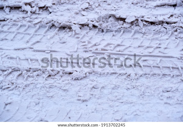 Snow-covered icy road in winter with packed snow\
close-up cloudy\
day