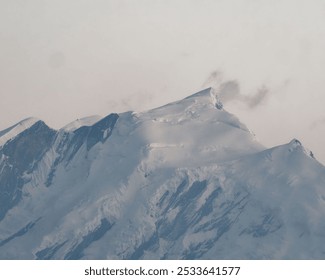 A snow-covered mountain peak with a cloudy sky. Poon Hill Trek, Annapurna mountain range, Nepal - Powered by Shutterstock