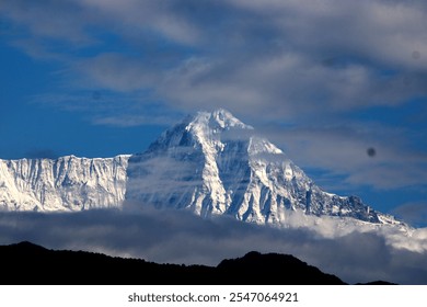 Snow-covered mountain peak under a partly cloudy sky. - Powered by Shutterstock