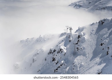 Snow-Covered Mountain Peaks with Cable Cars in Misty Winter Landscape - Powered by Shutterstock