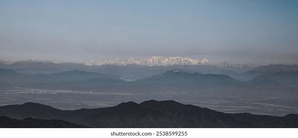 Snow-covered mountain peaks with rolling line of evergreens and mist in foreground. Bakhmaro, Georgia. oktober month. Sunlight illuminating snow covered mountain peaks towering over the tree line  - Powered by Shutterstock