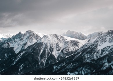 Snow-covered mountains, their peaks blanketed in white, create a stunning and serene winter landscape, highlighting the pristine beauty of the natural world - Powered by Shutterstock