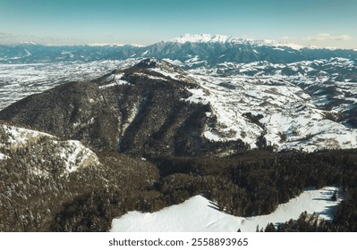 Snow-covered peaks dominate the landscape as sunlit valleys cradle the charming village of Rasnov. The serene beauty of Piatra Craiului National Park captivates during winter - Powered by Shutterstock