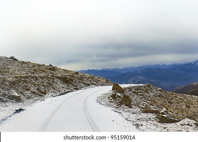 Snow-covered Road On A Mountain Pass In The Background