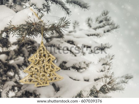 Snow-covered  spruce with a Christmas toy. Mass production. Vintage toning,