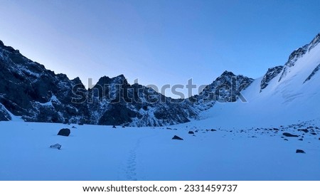 A snow-covered trail leading to the Delaunay Pass. Dawn in the Altai mountains. Climbing Mount Belukha. Beautiful morning mountain winter landscape. Amazing natural background.
