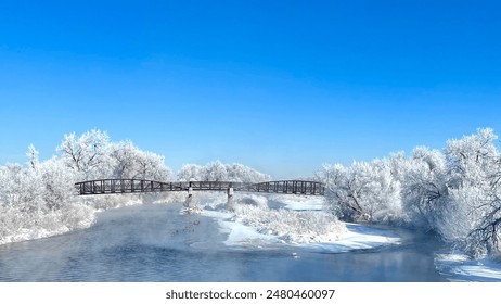 Snow-covered trees and bridge on riverbank in winter scene - Powered by Shutterstock