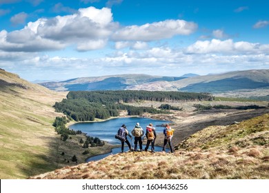 SNOWDONIA, WALES- MAY, 2019: A gaggle of vagabond hikers overlooking a beautiful vista in Snowdonia National Park unknowing of what the forest below has in store for them that evening. 