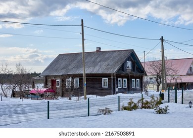 Snowdrifts near building in countryside in northern latitude in winter day.