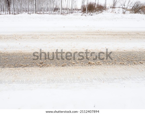 Snowdrifts on the side of the road. Bad\
weather and traffic. Snow on asphalt. Difficult driving conditions.\
Winter slosh on the road. Braking distance of a\
car