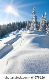 Snowdrifts On Winter Snow Covered Mountainside, Fir Trees On Hill Top And Sun Shine In Blue Sky. Beautiful Natural Winter Vacation Alps Hiking Travel To Nature Mountain Destinations Concept.