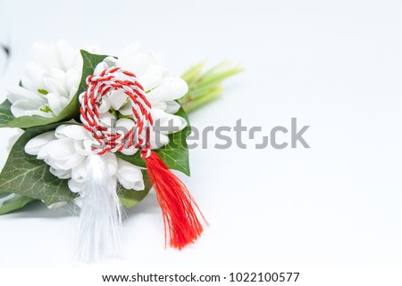 snowdrops and red and white string martisor on white with copy space east european first of march tradition celebration