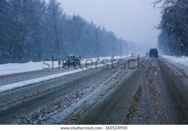 snowfall and fog on\
winter highway in\
twilight
