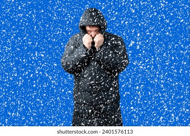 Snowfall and a man in a down jacket.Cold winter weather.