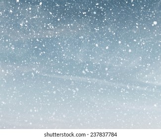 Snowfall On Cloudy Blue Sky