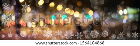Snowflake New Year winter pattern with white bokeh and spots on blurred defocused background of various street ligjts 