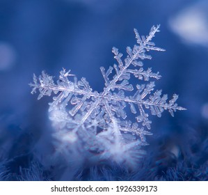 Snowflake With One Broken Branch On Blue Background