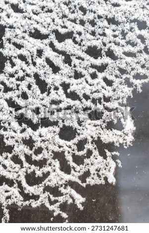 A snowflake pattern is shown on a window. The snowflake pattern is very intricate and detailed