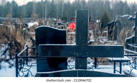 Snowing in the public cemetery. Traditional graveyard in winter under snow. Tombstone on the necropolis. Cemetery covered by snow in winter. Dramatic sky background. Space for text. - Powered by Shutterstock