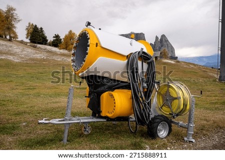 Snowmaking machine on alpine ski slope in Dolomites mountains