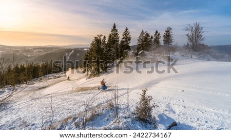 Snowmaking in the mountains in early winter. Tanvaldsky Spicak ski resort in Jizera Mountains, Czech Republic