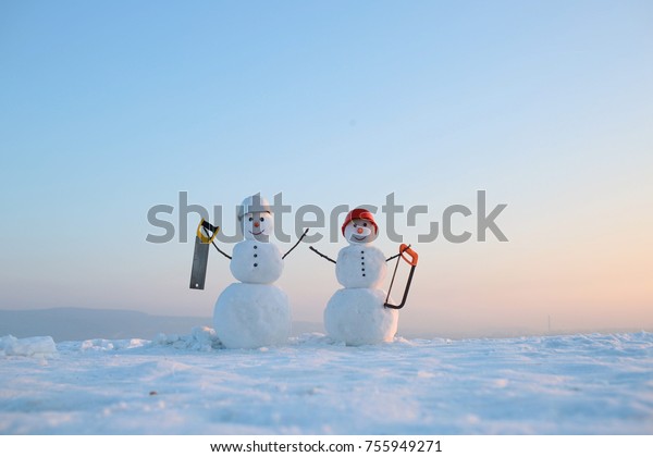 冬にヘルメットをかぶった雪だるま作りをする人 のこぎりで雪が降る新年の雪だるま 建築と修理の作業 祝祭日とお祝い クリスマスやクリスマスの飾り の写真素材 今すぐ編集