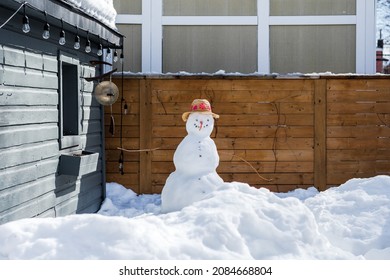 Snowman With Hat In Snowy Backyard.